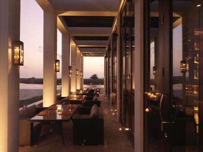 Elegant hotel restaurant with outdoor seating and warm evening lighting.