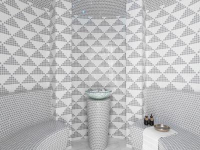 Modern steam room with gray mosaic tile walls, curved benches, and central pedestal sink.