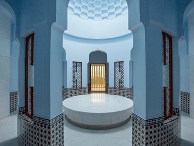 Round basin in blue-white arched interior with tiled walls and patterned ceiling.