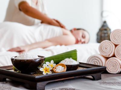 Relaxing massage scene with aromatherapy and stacked towels in spa setting.