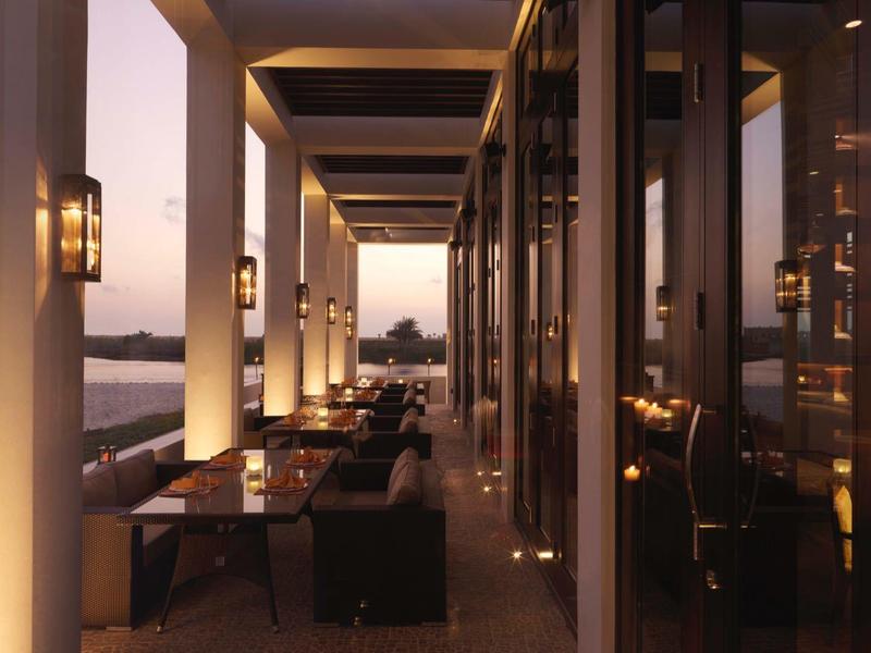 Elegant hotel restaurant with outdoor seating and warm evening lighting.