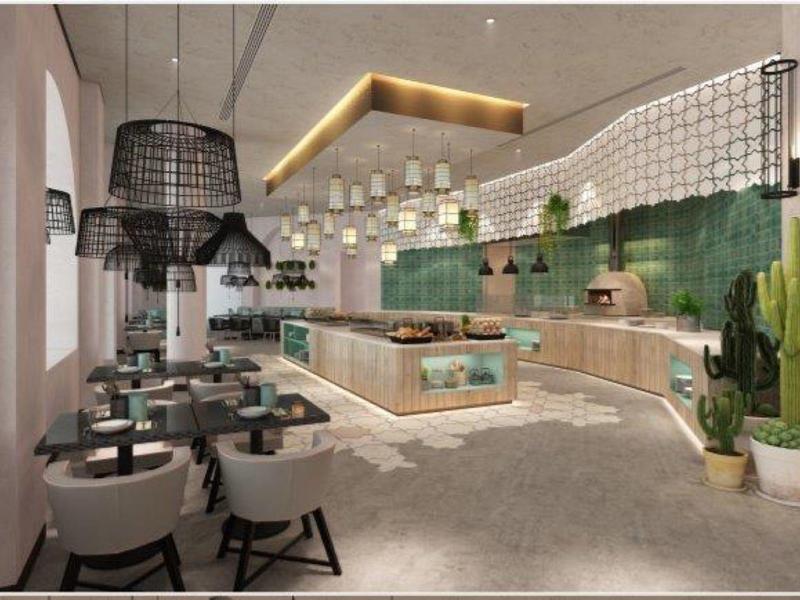 Modernes Café mit grünen Fliesen, hängenden Lampen und hellen Holzmöbeln in hellem Raum.