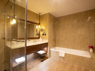 Modernes Badezimmer mit Badewanne, beleuchtetem Spiegel und einer Glasdusche.