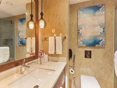 Moderner Badezimmerspiegel mit Doppelwaschbecken, goldene Wandleuchten und blauer Kunstdruck an Wand.