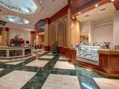 Luxusní hotelové lobby s mramorovou podlahou a stylovými dřevěnými doplňky.