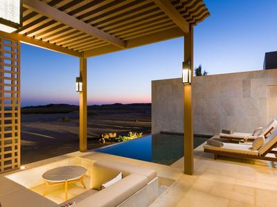 Espace extérieur moderne avec piscine, chaises longues et pergola au coucher du soleil