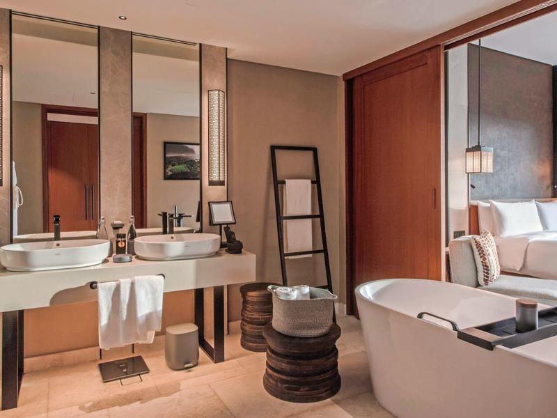 Chambre d'hôtel élégante avec baignoire indépendante et grand lavabo double.