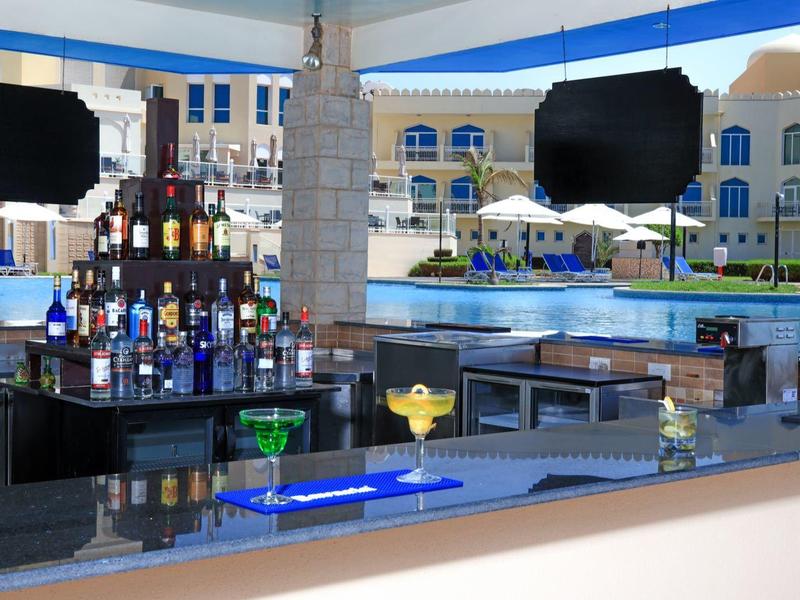 Moderne bar met drankjes naast een zwembad in een hotelresort