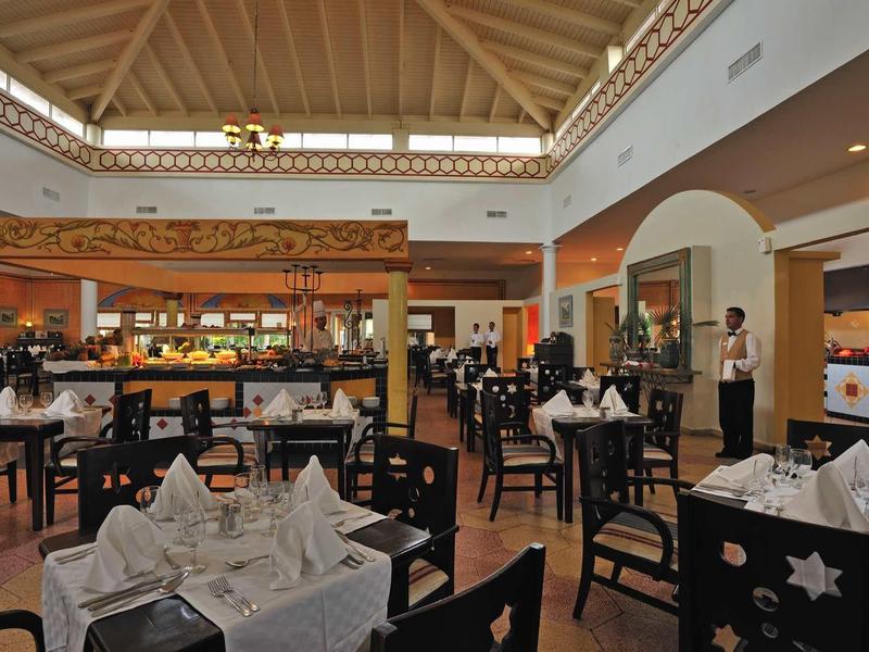 Großes Restaurant mit Holzdecke, schwarzen Stühlen und gedeckten Tischen in hellem Raum.