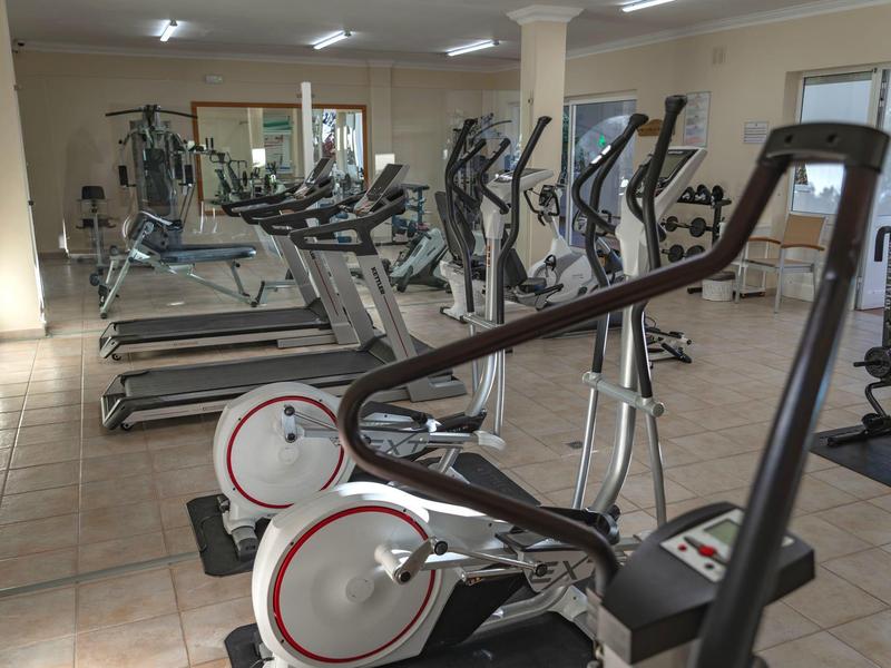 Modern fitness equipment in a bright, spacious hotel gym room.