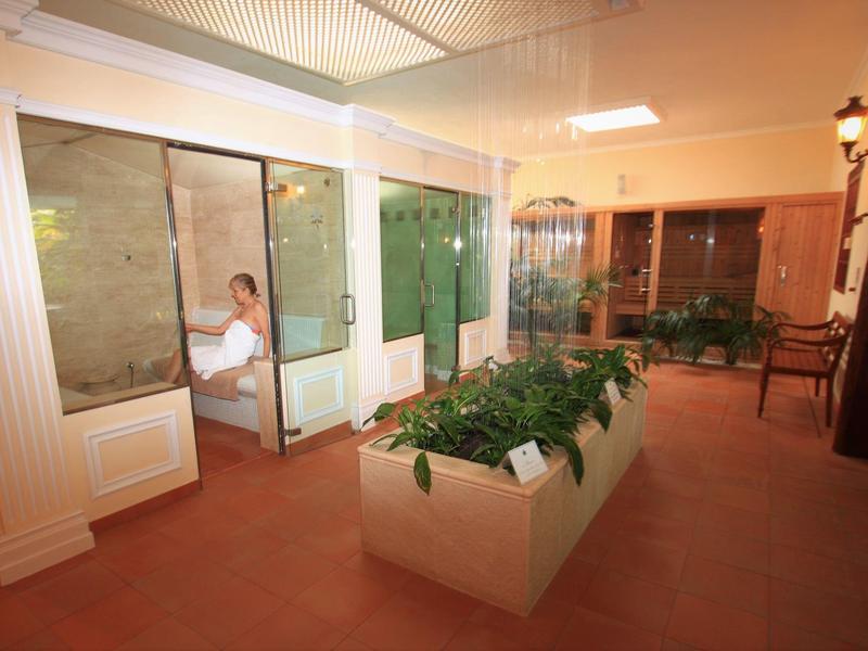 Cozy indoor area with bench, plants, and floor-to-ceiling window with a seated guest