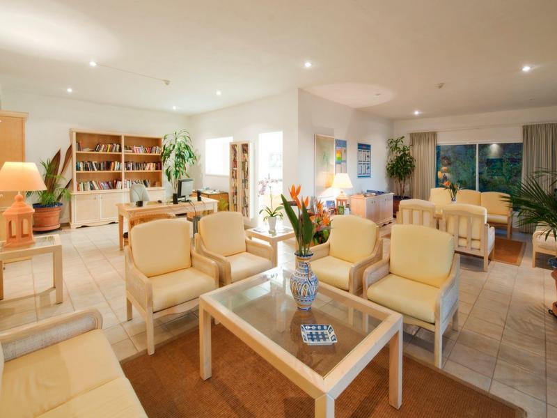 Bright, modern hotel lounge with comfortable armchairs and glass coffee table