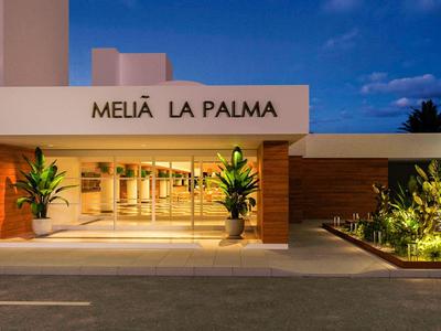 Ingang van hotel Melia La Palma bij schemering met verlichte planten.