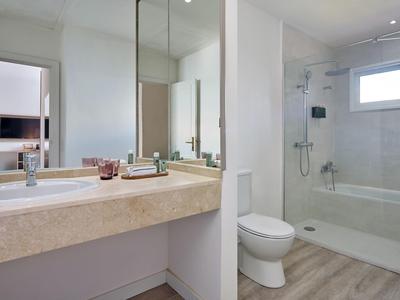 Moderne badkamer met wastafel, spiegel, toilet en douche met glazen wand