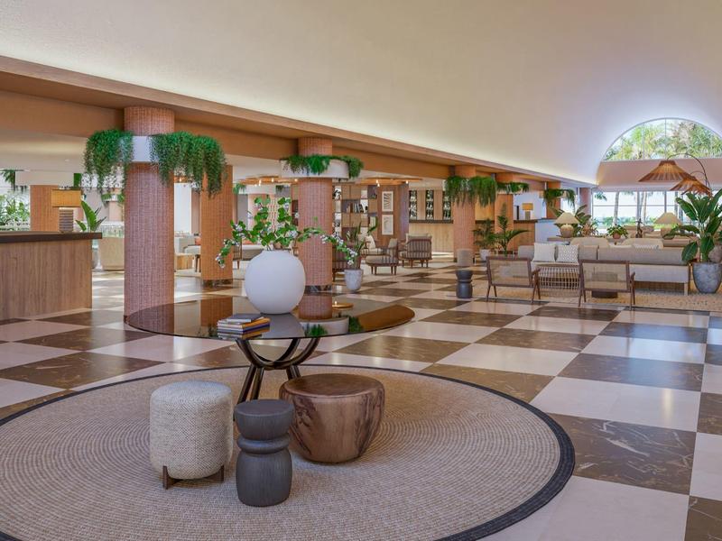 Ampia hall dell'hotel con pavimento in marmo decorato e area salotto moderna.