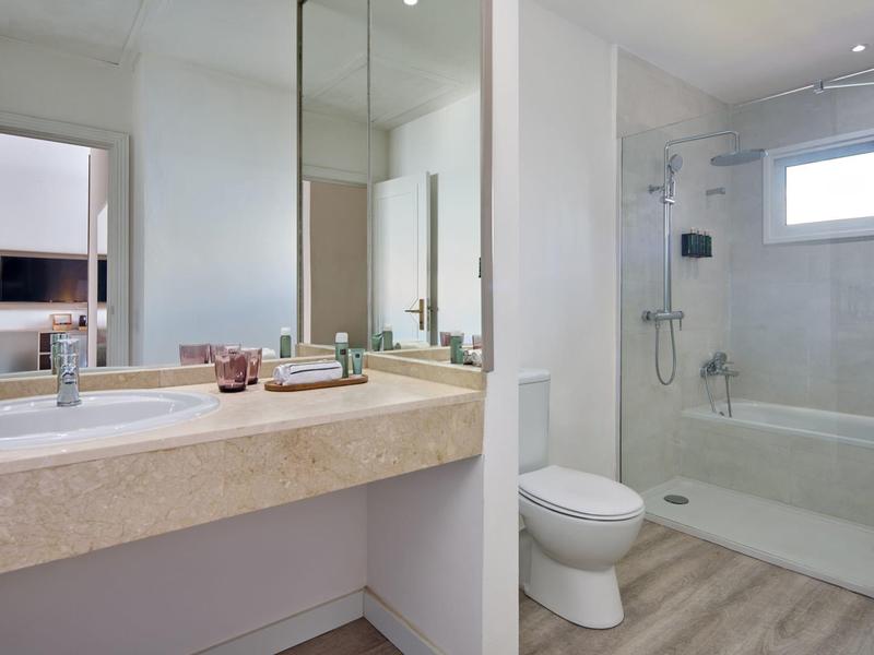 Moderne badkamer met wastafel, spiegel, toilet en douche met glazen wand