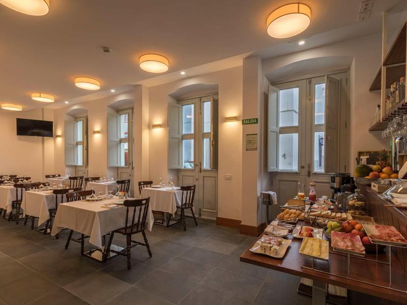 Innenraum eines Restaurants mit gedeckten Tischen, Holzboden und Buffet an der rechten Seite.