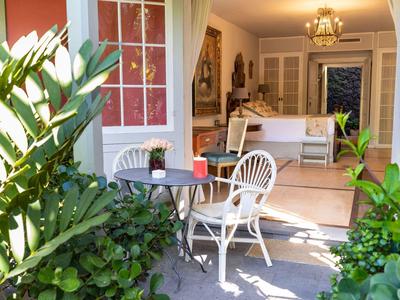 Cozy patio with table and chairs, view into a bright living room.