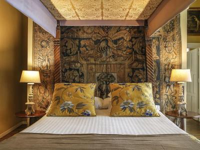 Elegant bedroom with decorative wall tapestry and two lamps beside the bed