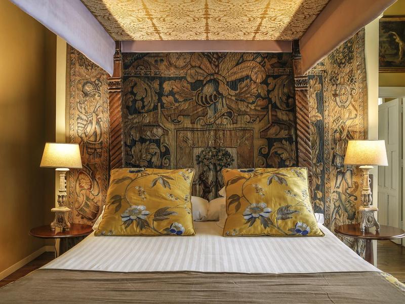 Elegant bedroom with decorative wall tapestry and two lamps beside the bed