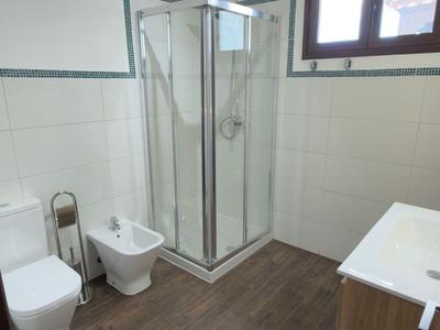 Nowoczesna łazienka hotelowa z kabiną prysznicową, toaletą, bidetem i umywalką.