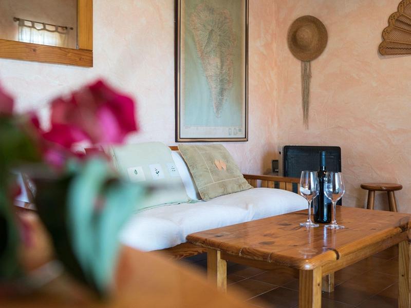 Pohodlný hotelový salonek s bílou pohovkou, dřevěným stolem a dekorativními prvky na zdi.