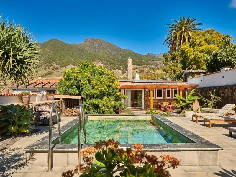 Bazén s deštníky a lehátky před domem v horské oblasti