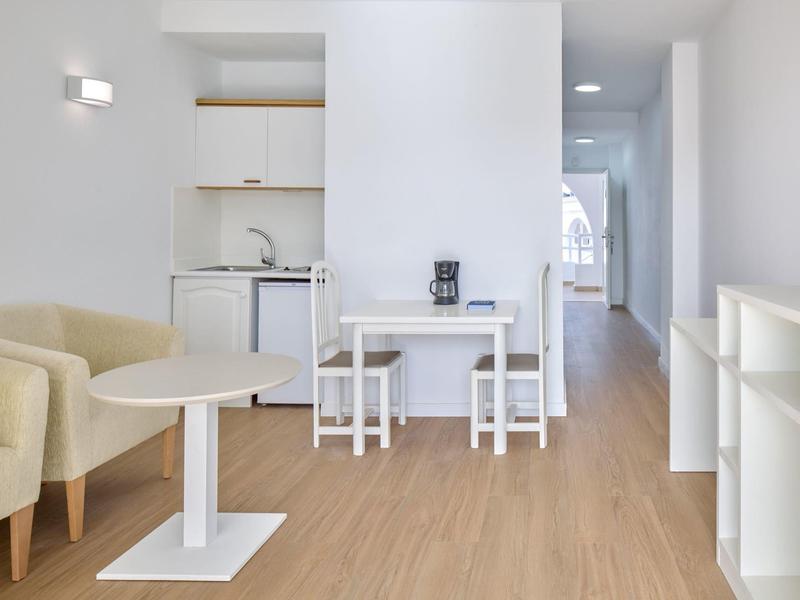 Bright, modern apartment with kitchenette, dining area, and seating.