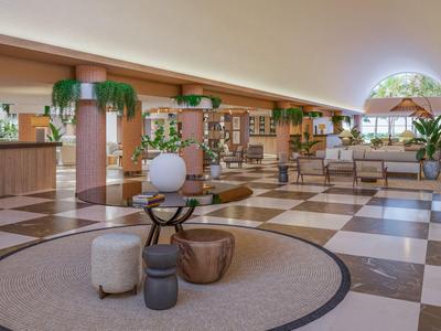 Hall d'hôtel lumineux avec sol en mosaïque, grandes fenêtres en arc et mobilier moderne.