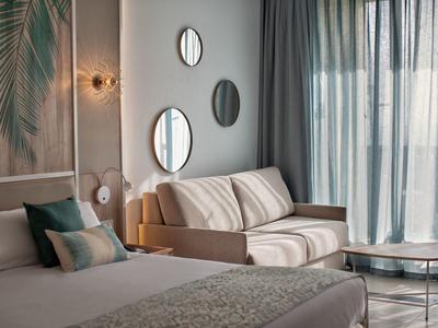 Modern hotelkamer met bed, bank, spiegels en grote ramen