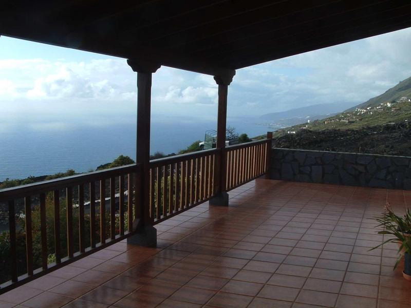 Terrazza coperta con ringhiera in legno con vista sul mare e sulle montagne