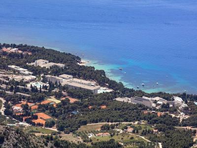 Coastal resort with several buildings and clear blue water in the background.