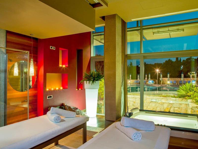 Modern spa with massage tables and a view of the pool area.