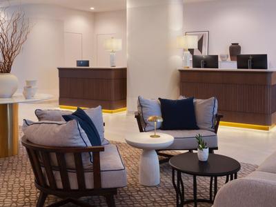 Gemütliche Lounge mit stilvollen Sesseln, kleinen Tischen und dezenter Beleuchtung.