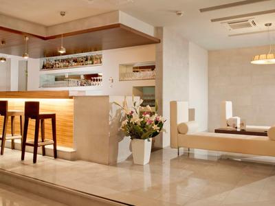 Eleganter Hotelbarbereich mit beleuchtetem Tresen, Hockern und modernen Sitzgelegenheiten.