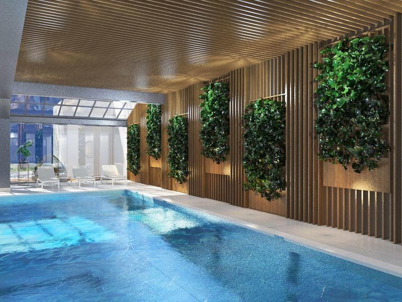 Innenraum mit großem Rechteck-Pool, hölzerner Decke, vertikalen Pflanzenwänden und viel Tageslicht.