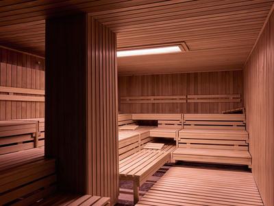 Innenraum einer Sauna mit mehrstufigen Holzbänken und Deckenverkleidung aus Holz.
