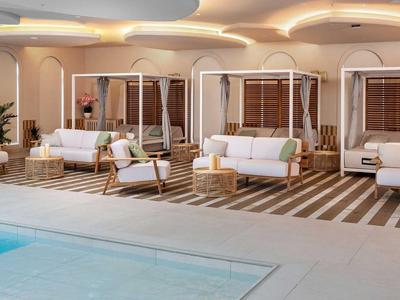 Eleganter Außenbereich mit Pool und stilvollen Sitzbereichen unter Holzjalousien und runden Deckenleuchten.