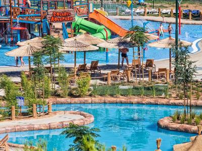 Waterpark met zwembaden, glijbanen en parasols in een hotelresort.