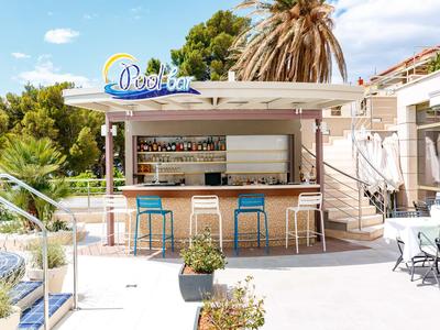 Moderner Außenbarbereich mit Stühlen und Palmen im sonnigen Hotelgarten