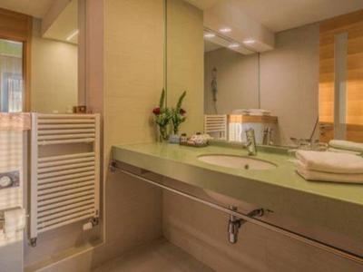 Nowoczesna łazienka z podwójnymi umywalkami, dużymi lustrami i ręcznikami.