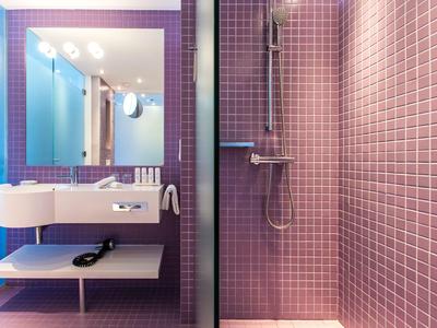 Modernes Badezimmer mit rosa Kacheln, Duschbereich und Doppelwaschbecken.