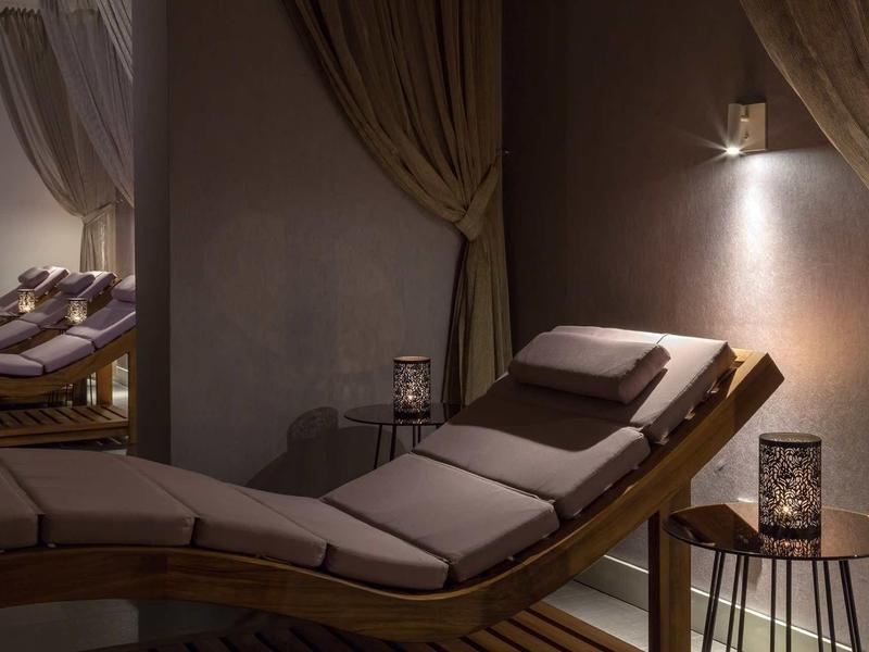 Pohodlné relaxační křeslo s polštáři a tlumeným osvětlením pro odpočinek v hotelu.