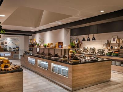 Moderne Buffetstation in einem stilvollen Hotelrestaurant mit vielfältigen Speisen und dekorativem Interieur.