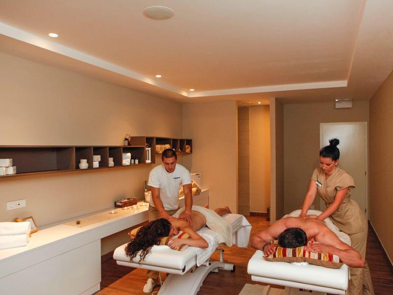 Deux femmes reçoivent des massages dans une salle de spa moderne et calme.