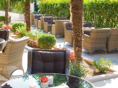 Gemütliche Outdoor-Terrasse mit Körbenmöbeln und grünem Pflanzenblick.