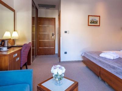 Chambre d'hôtel confortable avec lit, bureau, chaise et fleurs sur la table.