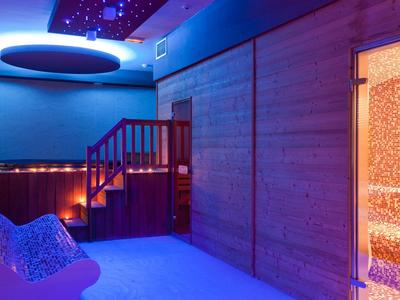 Espace bien-être moderne avec jacuzzi lumineux et sauna.