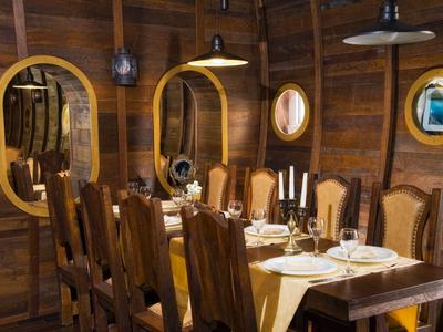 Rustikaler Speiseraum mit Holzmöbeln, Tischgedeck und Spiegeln an den Wänden.