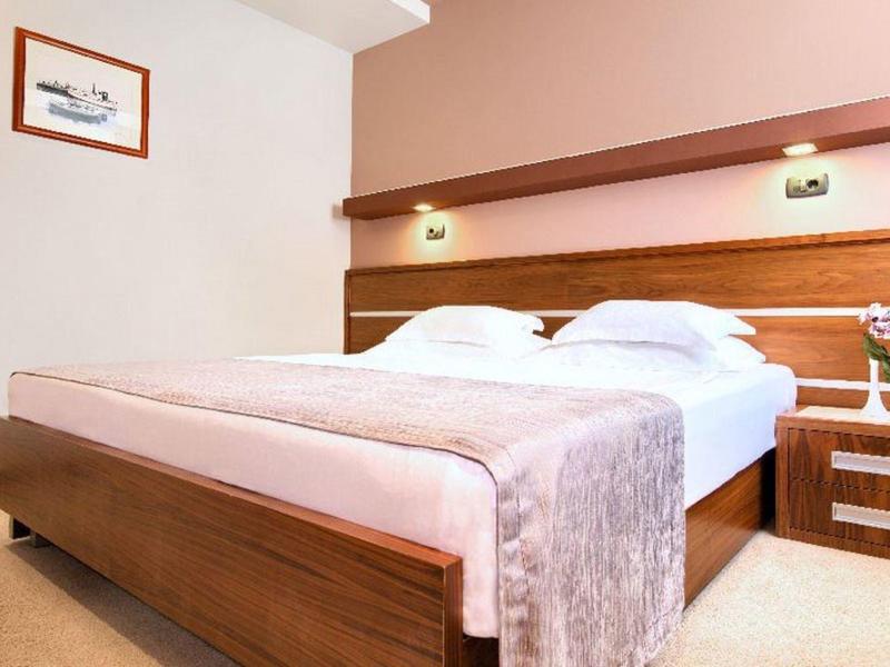 Chambre d'hôtel moderne avec lit double, mobilier en bois et ambiance calme.